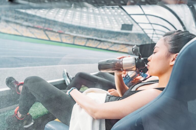 Woman hydrating after sports training at a stadium during a Formula 1 race break
